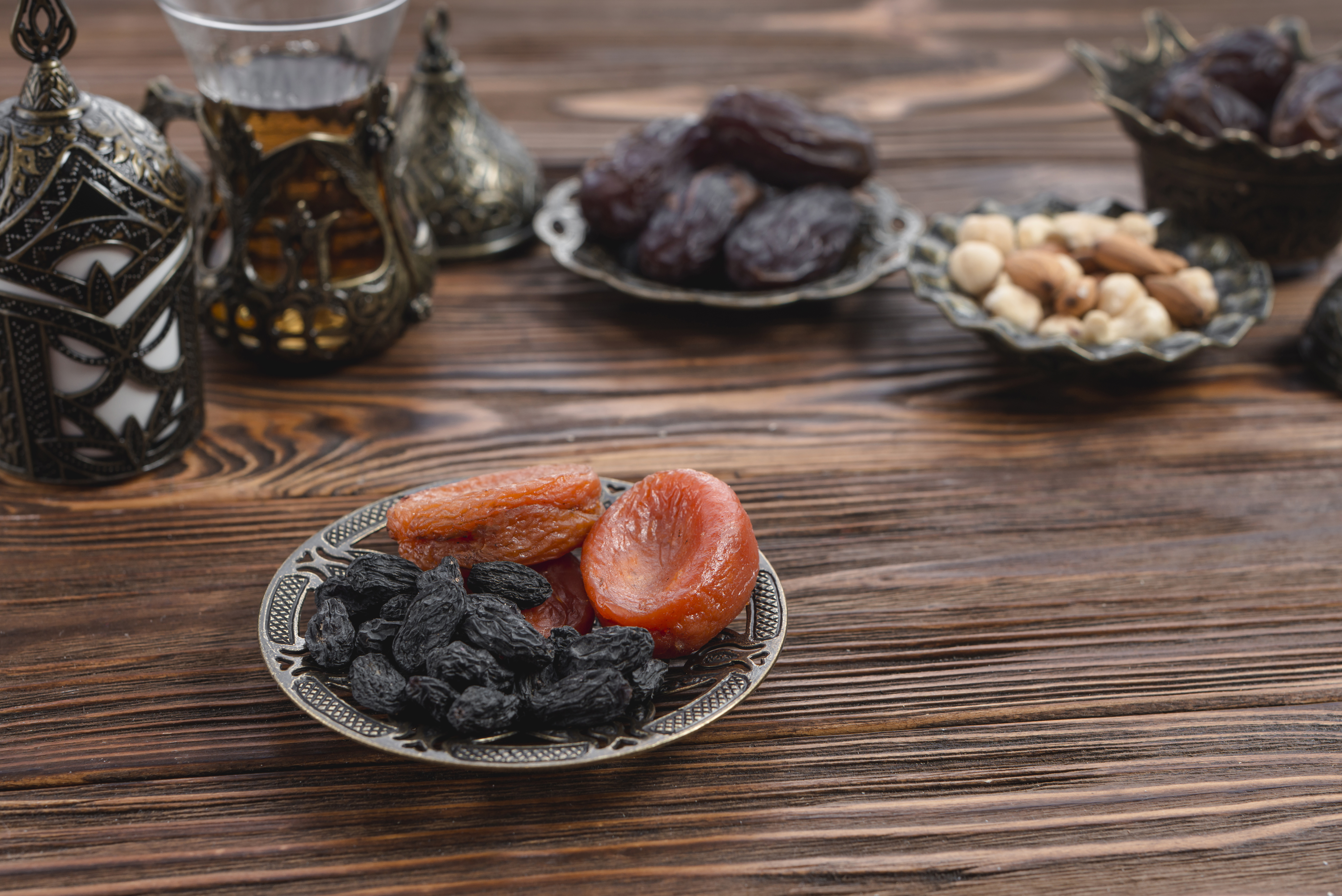 2023-resimli-ramazan-mesajlari-dried-apricot-black-raisin-metallic-plate-wooden-textured-backdrop
